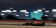 Oracle Red Bull Racing Team vehicle on the rice track with a building with lights on the background Oracle Red Bull Racing Team vehicle on the rice track with a building with lights on the background
