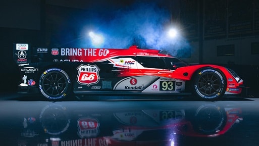 2026 Honda ARX-06 in red profile in a dark studio with dramatic lighting, smoke, and floor reflection.