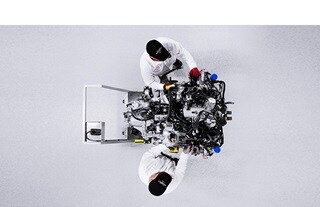 Overhead view of two technicians working on NSX engine. 