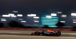 Oracle Red Bull Racing Team vehicle on the rice track with a building with lights on the background Oracle Red Bull Racing Team vehicle on the rice track with a building with lights on the background