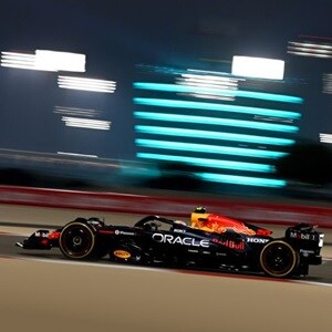 Oracle Red Bull Racing  Team vehicle on the rice track with a building with lights on the background Oracle Red Bull Racing  Team vehicle on the rice track with a building with lights on the background