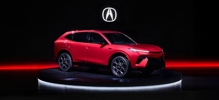 2026 Acura Hybrid 7/8 front on a dark studio stage with red lighting accents.