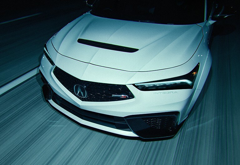 Acura Integra Type S in motion, front close up showing grille with Type S badge and headlight