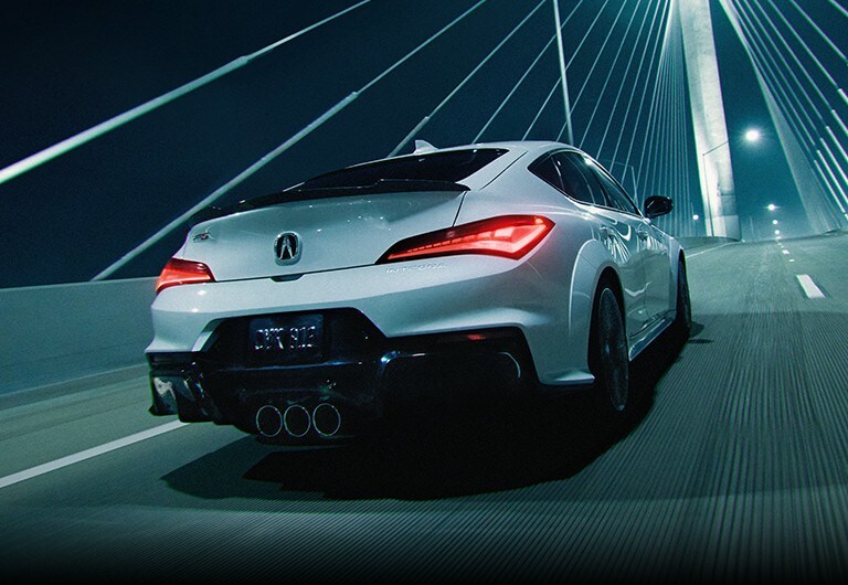Acura Integra Type S in Platinum White Pearl, rear view crossing a bridge at night