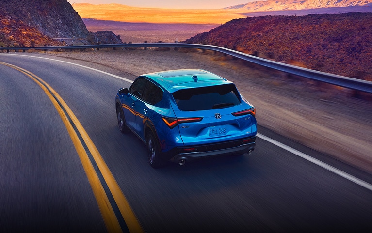 2026 Acura ADX A-Spec shown in Double Apex Blue Pearl II, driving on the road.