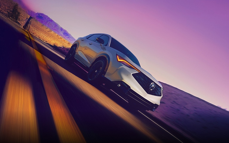 2026 Acura ADX A-Spec shown in Platinum White Pearl, driving on the road.