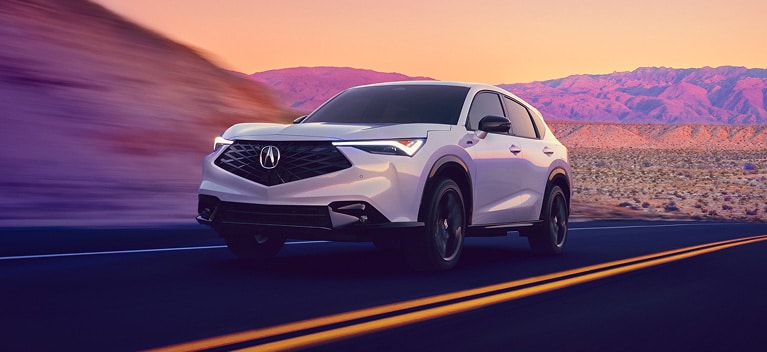 2026 Acura ADX A-Spec shown in Platinum White Pearl, driving on the road.