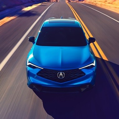 2026 Acura ADX A-Spec shown in Double Apex Blue Pearl II, driving on the road.