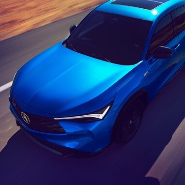 2026 Acura ADX A-Spec shown in Double Apex Blue Pearl II, driving on the road.