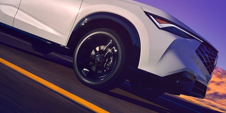 2026 Acura ADX A-Spec shown in Platinum White Pearl, driving on the road.