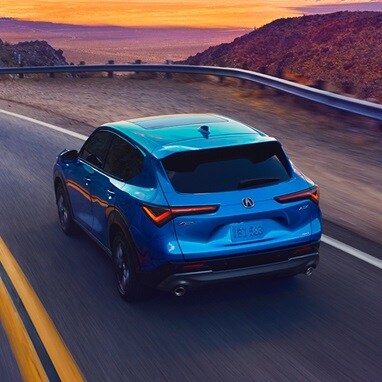2026 Acura ADX A-Spec shown in Double Apex Blue Pearl II, driving on the road.