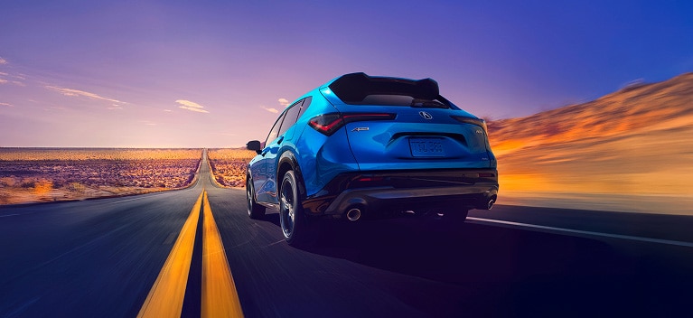 2026 Acura ADX A-Spec shown in Double Apex Blue Pearl II, driving on the road.