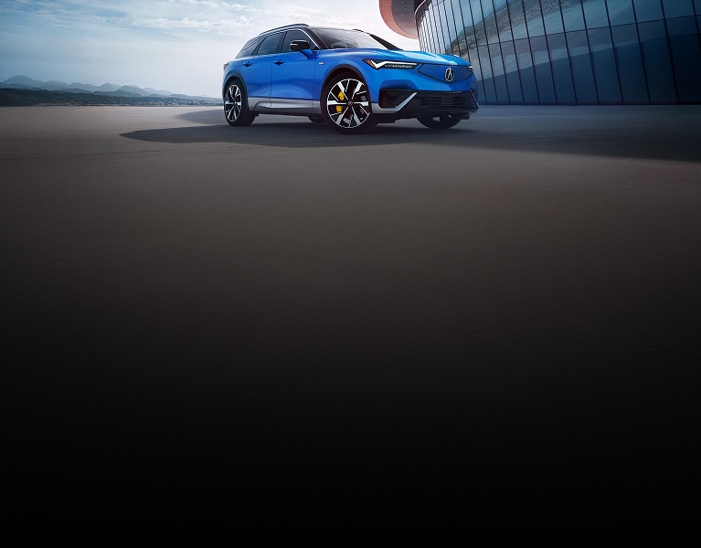 2024 Acura ZDX Type S in Double Apex Blue Pearl, parked in front of a modern building (Premium All-Electric SUV).