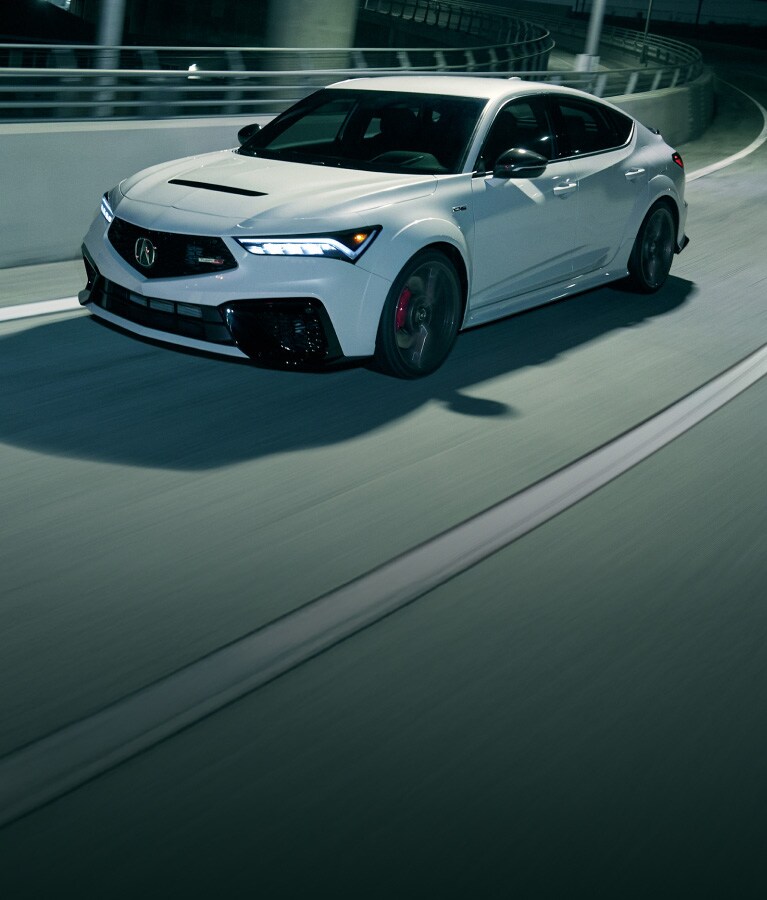 2026 Acura Integra Type S shown in Platinum White Pearl, driving across the city.