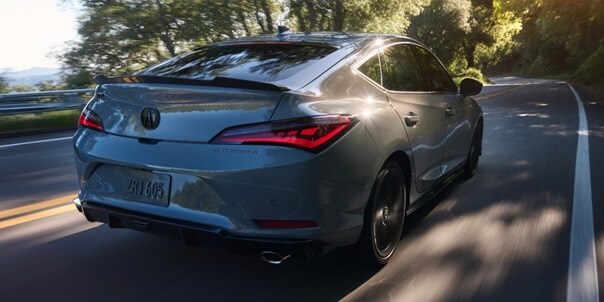 2026 Acura Integra car in Urban Gray Pearl driving on the road. 2026 Acura Integra car in Urban Gray Pearl driving on the road.