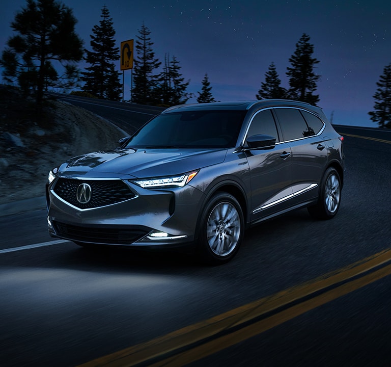 2024 Acura MDX Advance in Liquid Carbon Metallic driving at night 