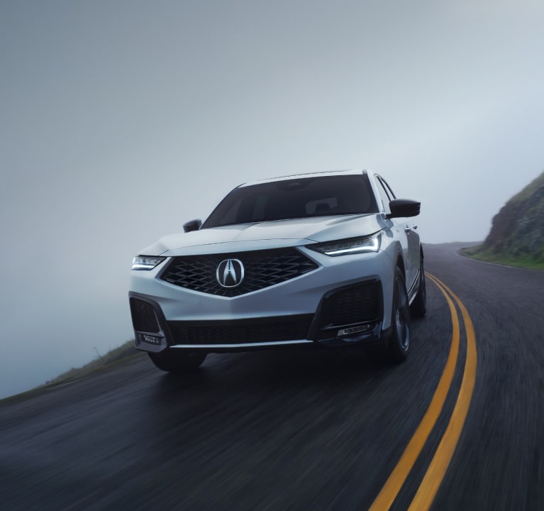 2025 Acura MDX Advance Package in Platinum White Pearl driving on road
