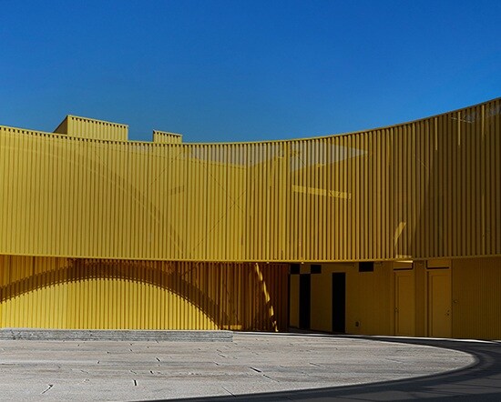Acura 2026 RDX Technology in Liquid Carbon profile view with a yellow building at the background