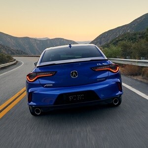 2025 Acura TLX A-Spec Package in Apex Blue Pearl rear view on the road.