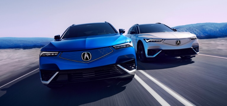 2024 Acura ZDX Type S in Double Apex Blue Pearl and ZDX Type S in Snowfall Pearl driving on a road side by side