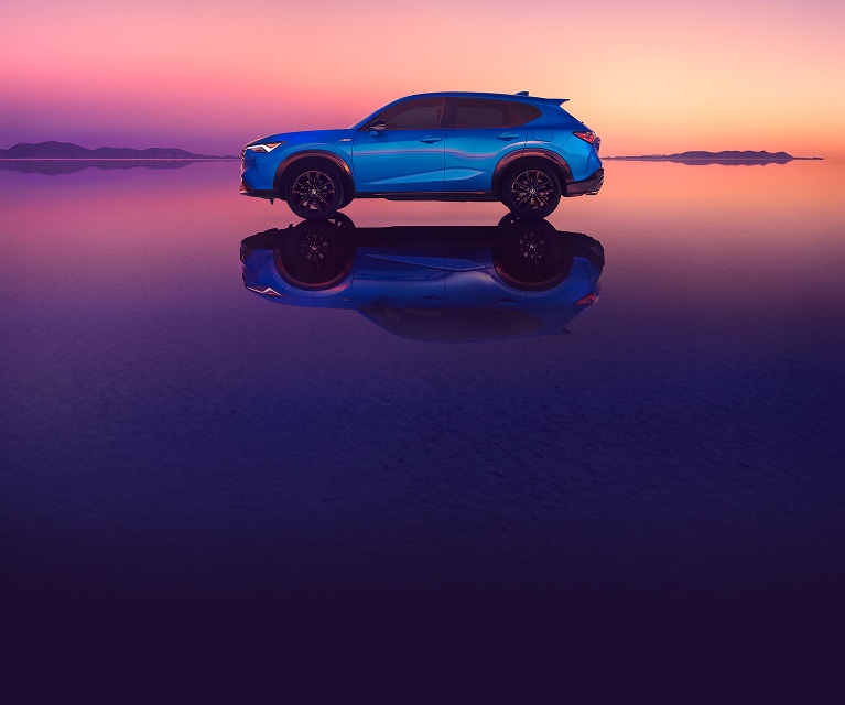 2026 Acura ADX in Adriatic Sea Blue Metallic profile on salt flats at sunset with reflection. (Premium Compact SUV).
