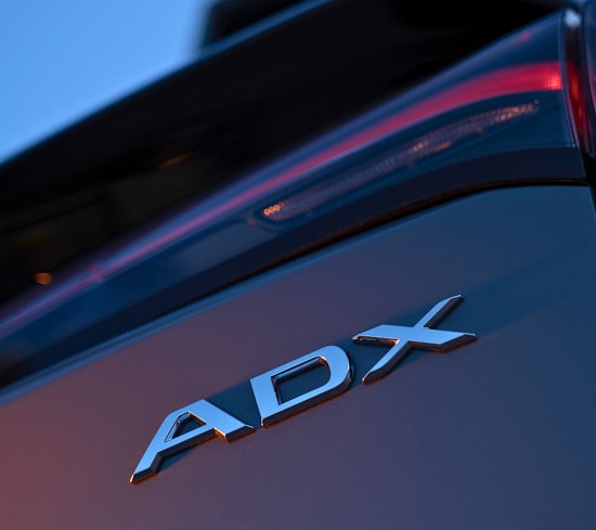 2026 Acura ADX back close up of the rear emblem at dusk (Premium Compact SUV).