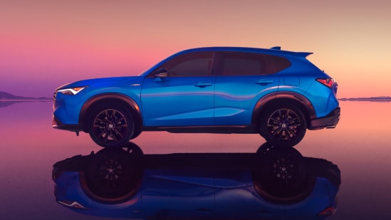 2026 Acura ADX in Adriatic Sea Blue Metallic profile on salt flats at sunset with reflection (Premium Compact SUV).