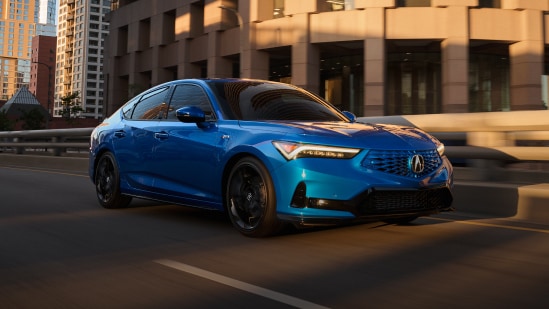 2026 Acura Integra A-Spec with Technology in Double Apex Blue Pearl front driving on a city street (Premium Sport Compact).