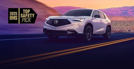 2025 Acura ADX A-Spec in Platinum White Pearl front three-quarter view driving on a desert road at sunset 