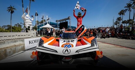 Acura Grand Prix of Long Beach win, race car in a front view in the pit lane with the team celebrating.