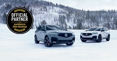 Acura MDX in Urban Gray Pearl and Platinum White Pearl parked in the snow with an Official Partner logo for the 2026 Sundance Film Festival