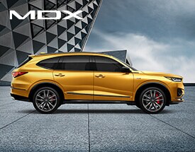 MDX Type S profile view with modern building on the background